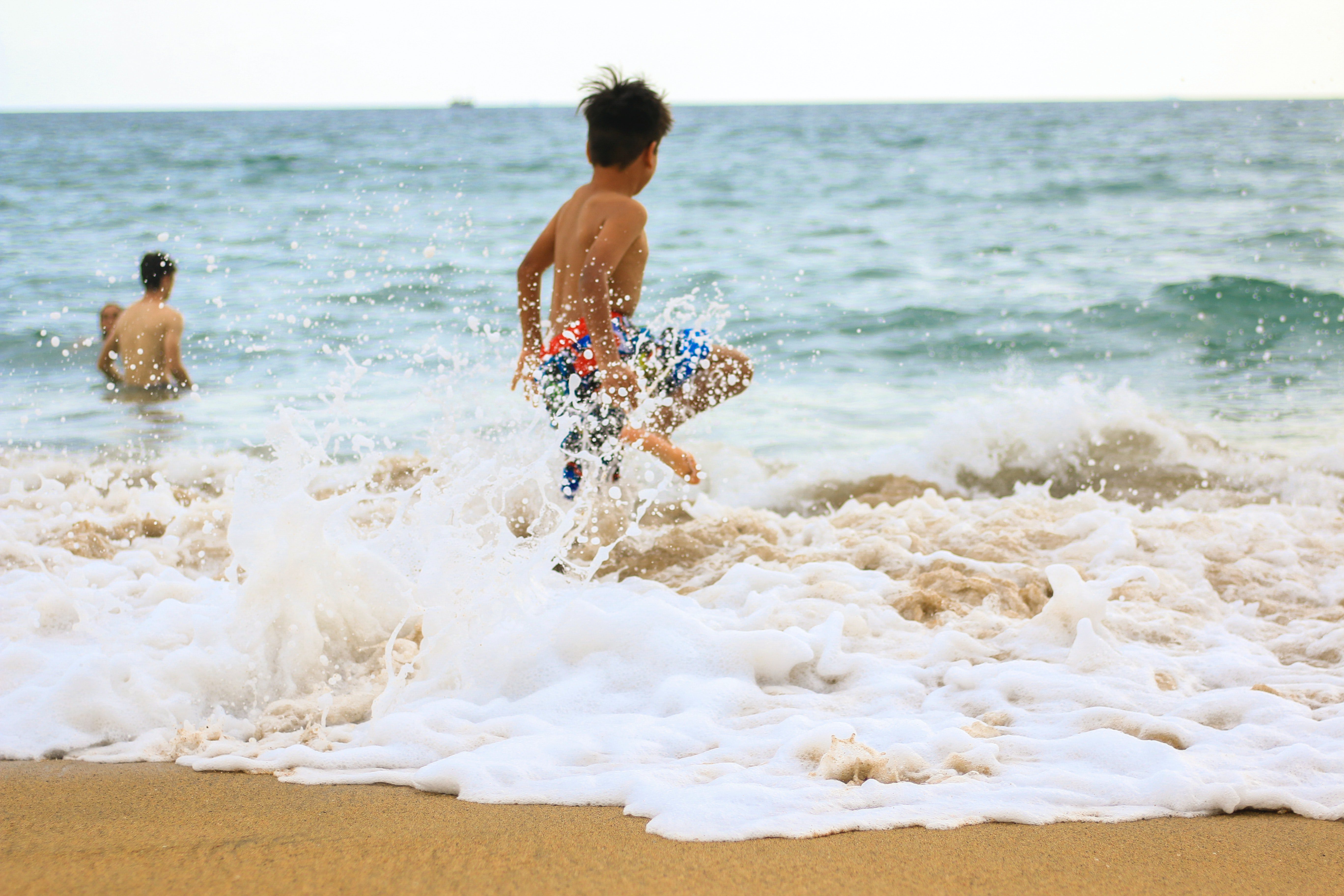 photo of a boy rushing towards the sea