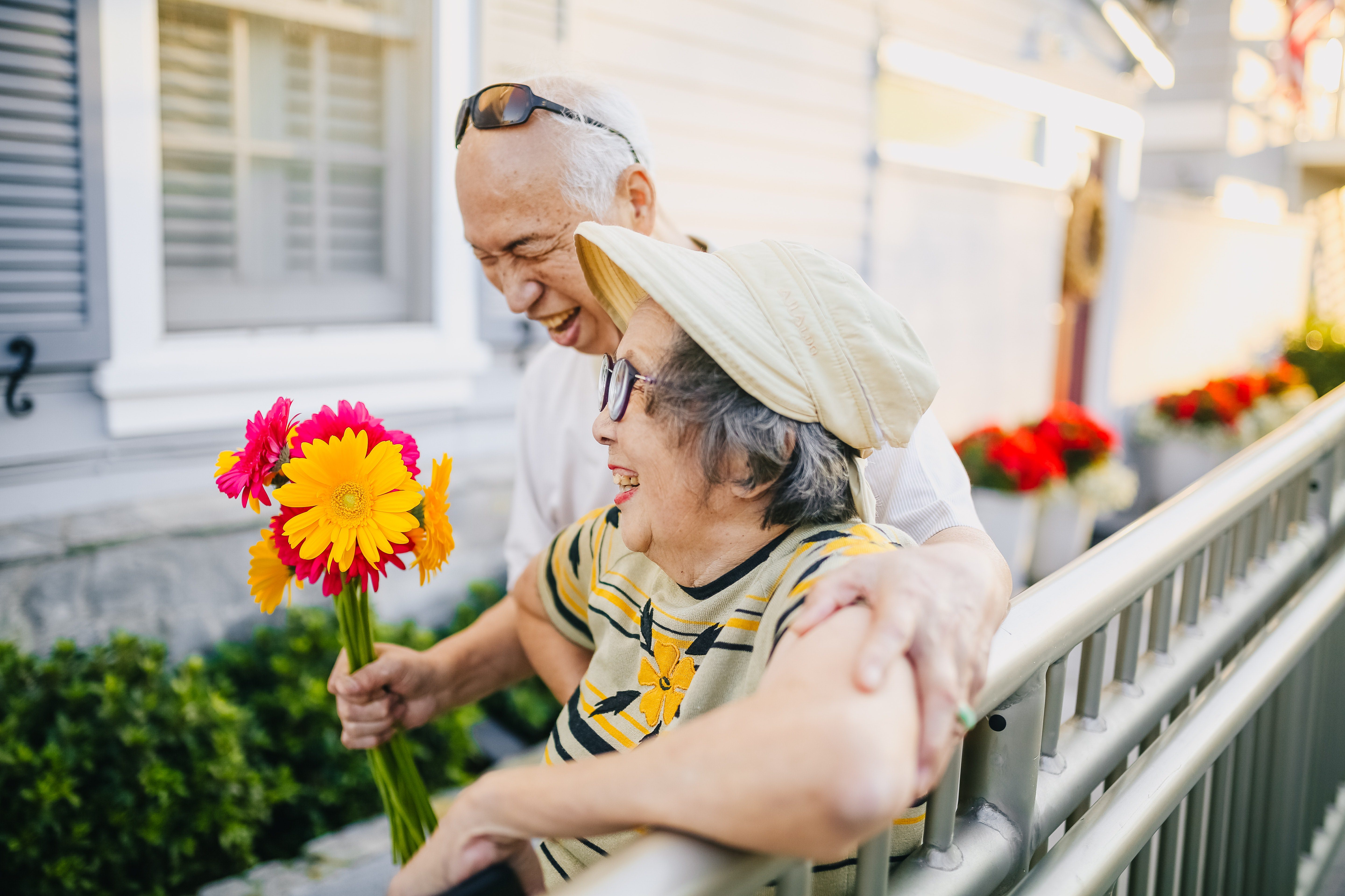 elderly couple holding flowers